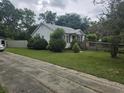 Cozy home featuring a wheelchair ramp, fence, and trees at 207 Cedar St, Saint George, SC 29477