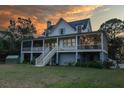 Charming raised home with a wraparound porch, offering ample outdoor living space and picturesque views at 2312 Rushland Landing Rd, Johns Island, SC 29455