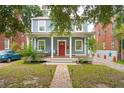 Inviting home with a welcoming front porch, featuring a bright red door and a quaint seating area at 293 Grove St, Charleston, SC 29403