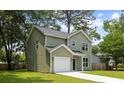 Angle view of a charming two-story home with light green siding and a one-car garage at 2960 Blackfish Rd, Johns Island, SC 29455