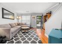 Bright living room with a gray sectional couch, wood floors, and front door view at 507 Stinson Dr # B3, Charleston, SC 29407