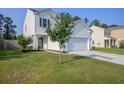Beautiful two-story home featuring a well-manicured lawn and a two-car garage, complemented by lush landscaping at 596 Wayton Cir, Moncks Corner, SC 29461