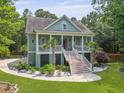 Charming two-story home featuring a wide front porch, decorative columns, and beautiful landscaping at 800 Enclave Ter, Summerville, SC 29483