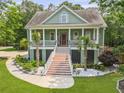 Charming two-story home featuring a wide front porch, decorative columns, and beautiful landscaping at 800 Enclave Ter, Summerville, SC 29483