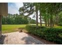 Picturesque backyard with a stone patio overlooks a manicured golf course, framed by mature trees and lush greenery at 801 Ventura Pl, Mount Pleasant, SC 29464