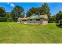 Brick home with a well-kept lawn and detached garage with a sunny sky in the background at 840 Brittle Bank Rd, Walterboro, SC 29488