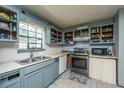 The kitchen has blue cabinets and includes an oven, dishwasher and a double sink at 1004 Miles Jamison Rd, Summerville, SC 29485