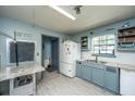 This kitchen includes a refrigerator, double sink, and a blue accent wall at 1004 Miles Jamison Rd, Summerville, SC 29485