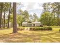 Beautiful single-story home with a metal roof and garage surrounded by tall trees and green lawn at 1044 Academy Rd, Walterboro, SC 29488