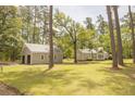 Exterior showcases home and garage with a lush green lawn and mature trees on a sunny day at 1044 Academy Rd, Walterboro, SC 29488
