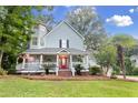 Two-story home features a charming front porch, mature trees, and well manicured front yard at 111 Long Bow Rd, Summerville, SC 29485