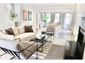 Bright, open-concept living room features modern furniture, light wood floors, and lots of natural light at 1119 Morning Glory Ct, Mount Pleasant, SC 29464