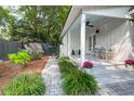 Inviting side porch with white columns, chairs, and manicured landscaping, creating a cozy outdoor space at 1151 Camellia Dr, Mount Pleasant, SC 29464