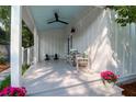 Side porch featuring white columns, a ceiling fan, and comfortable seating, perfect for relaxing and enjoying the outdoors at 1151 Camellia Dr, Mount Pleasant, SC 29464