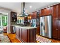 Gourmet kitchen with wood cabinets, stainless steel appliances, a granite island, and hardwood floors at 127 White Pine Way, Summerville, SC 29485