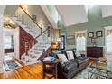 Inviting living room featuring a dramatic staircase, vaulted ceiling, and a comfortable leather sofa at 127 White Pine Way, Summerville, SC 29485