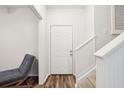 Neutral entryway with wood floors and stairs to the second level and a gray accent chair at 130 River Landing Dr # 8203, Charleston, SC 29492