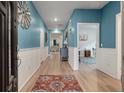 Inviting hallway with wainscoting, stylish decor, and wood-look floors leading to various rooms at 1384 Locals St, Summerville, SC 29485