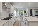 Modern kitchen with white cabinets, stainless steel appliances, and a view to the breakfast nook at 1384 Locals St, Summerville, SC 29485