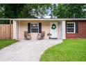 Inviting front porch with seating, a charming wreath on the door, and well-manicured lawn enhance the curb appeal at 14 Aldene Ave, Goose Creek, SC 29445