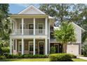 A two story home features double porches, gray paint, mature trees and manicured landscaping at 1405 Mataoka St, Mount Pleasant, SC 29464