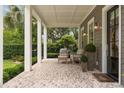 Inviting front porch with brick flooring, comfortable seating, and charming outdoor lighting fixtures at 1405 Mataoka St, Mount Pleasant, SC 29464