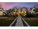 Luxury home with exterior night view, featuring a wooden walkway, and beautiful landscaping at 156 Nobels Point St, Charleston, SC 29492