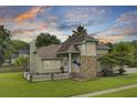 Charming home with brick accents, manicured lawn and inviting front porch at sunset at 16 Oatly Cir, Charleston, SC 29414