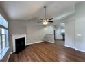 Inviting living room with wood floors, fireplace, ceiling fan, and an open layout leading to the kitchen at 1705 Falcon Cove Ln, Hanahan, SC 29410