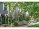Charming two-story home with a white picket fence, surrounded by lush greenery and an American flag at 173 Fishburne St, Charleston, SC 29403