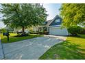 Well-manicured lawn with long driveway leading to a blue home with a two-car garage and inviting front porch at 185 Red Leaf Blvd, Moncks Corner, SC 29461