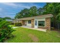 A quaint single-story home with brick accents, surrounded by lush greenery and a well-kept lawn at 2003 Savage Rd, Charleston, SC 29407