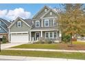 Attractive home with a well-maintained lawn, covered front porch, and a two-car garage on a sunny day at 202 Center Hill Ct, Summerville, SC 29485