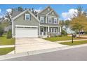 Well-maintained home featuring a covered front porch and a two-car garage with a white pergola detail over the entrance at 202 Center Hill Ct, Summerville, SC 29485