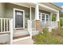 Inviting covered front porch with white railings, brick-based columns, and a welcoming front door with glass panes at 202 Center Hill Ct, Summerville, SC 29485