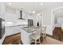 Modern white kitchen featuring stainless steel appliances, granite countertops, and a stylish kitchen island at 2208 Primus Rd, Mount Pleasant, SC 29466