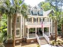 Elegant two-story home boasts a double porch adorned with an American flag, offering a charming curb appeal at 2225 Black Oak Ct, Mount Pleasant, SC 29466