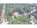Aerial view of a home with a red roof surrounded by lush trees on a spacious lot at 236 Chamblee Rd, Walterboro, SC 29488