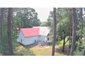 Rear exterior view of a home with a red roof, white siding, and a small back deck at 236 Chamblee Rd, Walterboro, SC 29488