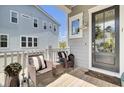 Inviting front porch featuring comfortable wicker seating with stylish black and white striped cushions at 2928 Tranquility Rd, Mount Pleasant, SC 29466