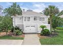 Charming two-story home featuring a well-manicured lawn and a two-car garage at 30 Beachside Dr, Isle of Palms, SC 29451