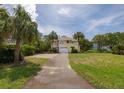 Charming two-story home features lush landscaping, a driveway, and a two-car garage at 30 Beachside Dr, Isle of Palms, SC 29451
