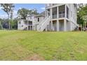 Expansive backyard of a charming two-story home with white stairs and manicured lawn at 3029 Robeson Trce, Johns Island, SC 29455