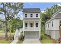 Charming two-story home with a white garage, inviting porch, and meticulously landscaped front yard at 3029 Robeson Trce, Johns Island, SC 29455