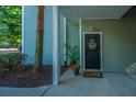 Charming condo front door with a welcome wreath, potted plant, and lovely tree at 401 S Elgin Ct # 401, Charleston, SC 29414