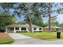 White brick home with well-kept lawn, mature trees, attached carport, and a mailbox at 403 Wedgewood St, Charleston, SC 29407