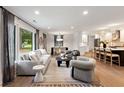Modern living room with hardwood floors, stylish furnishings, large window, and seamless flow to the kitchen at 403 Wedgewood St, Charleston, SC 29407