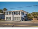 Charming two-story home, featuring a white exterior and stairs at 405 Palmetto Blvd, Edisto Island, SC 29438