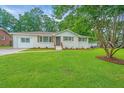 Charming single-story home features a well-manicured lawn and inviting front porch at 4233 Oakridge Dr, North Charleston, SC 29418
