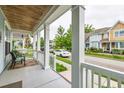 Cozy front porch provides a relaxing outdoor space with seating and a charming neighborhood view at 4953 W Liberty Park Cir, North Charleston, SC 29405